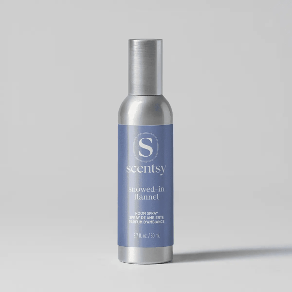 Silver spray bottle with a blue label featuring the Scentsy logo and "Snowed-In Flannel Room Spray" text, 2.7 fl oz size