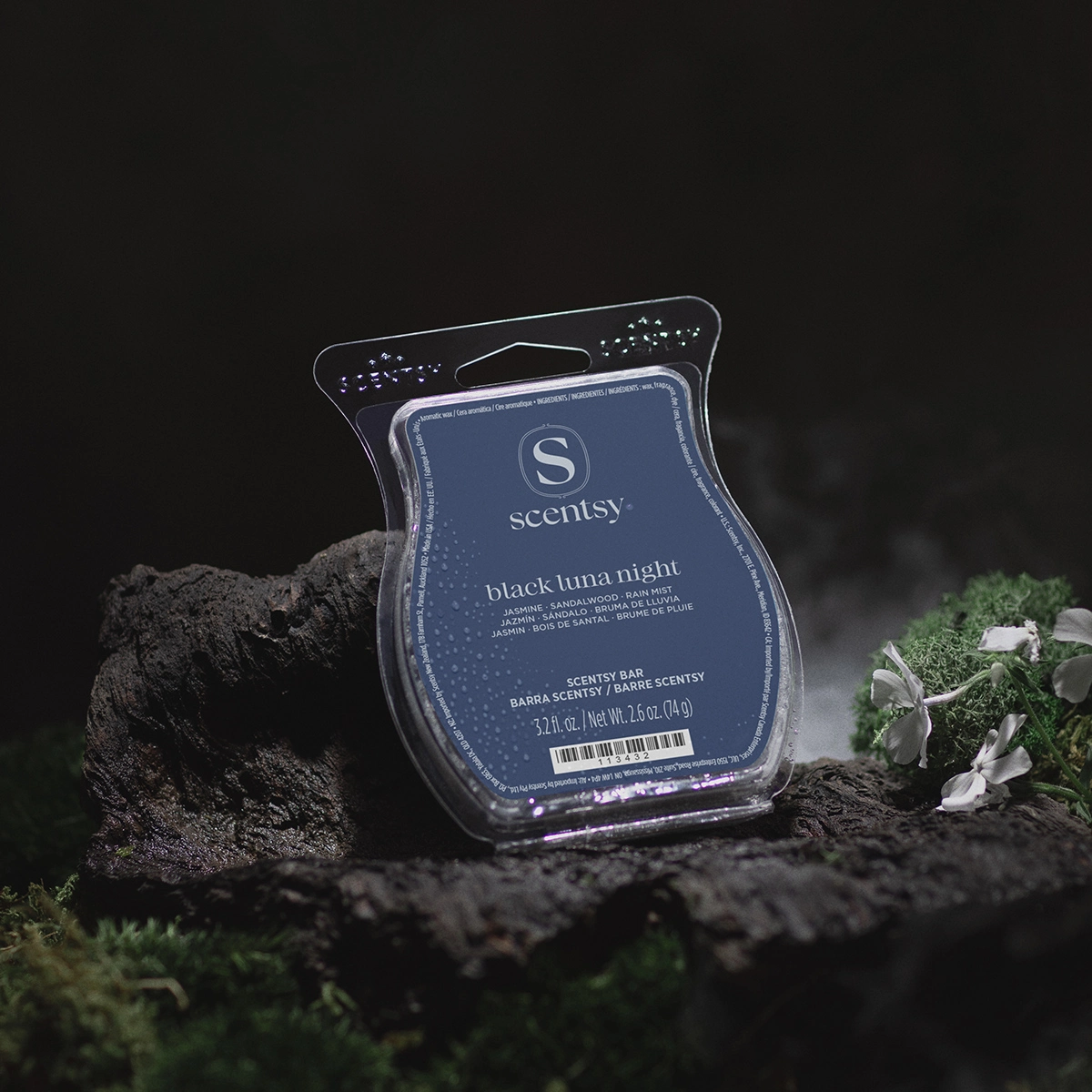 Scentsy Bar in dark blue clamshell packaging with the scent name "black luna night" displayed on the label, surrounded by dark rocks and green moss against a black background