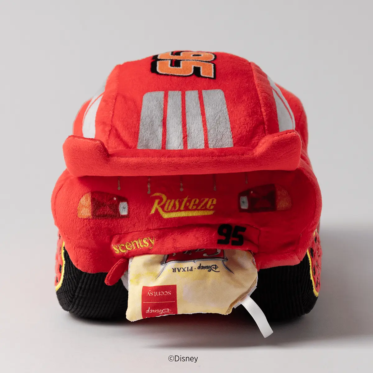 Red plush race car character with grey racing stripes, white side stripe, orange number 95, and black lower body with yellow accents