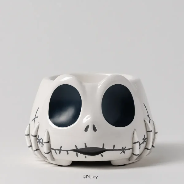 White ceramic warmer shaped like a skull with large oval black eyes, a stitched mouth, and stitched detail on the cheeks and sides, the Disney Jack Skellington: Warm Fuzzies Scentsy Warmer