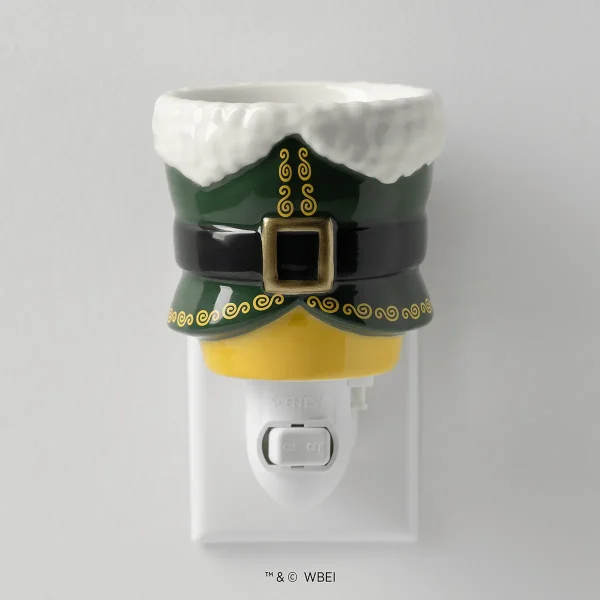 White ceramic wall plug warmer styled as an elf with a green hat trimmed in white faux fur, gold curled details, black belt with gold buckle, and yellow shirt, the Elf: Buddy’s Christmas Joy Mini Scentsy Warmer