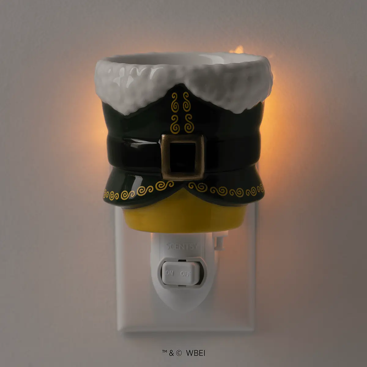 Mini Scentsy Warmer shaped like Santa's black coat with white fur trim, gold belt buckle and buttons, and yellow mittens, plugged into a wall outlet with warm light glowing inside