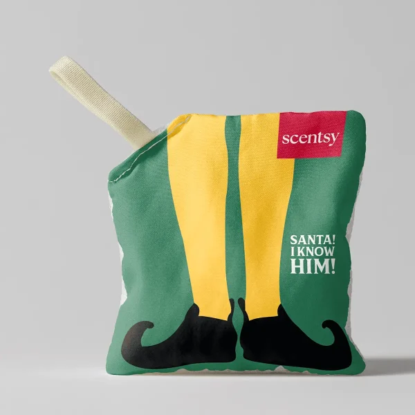Festive square plush Scent Pak with green base, yellow and green striped centre, black elf shoes, red label, cream handle, and white text reading "SANTA! I KNOW HIM!", the Elf: SANTA! I KNOW HIM! Scent Pak