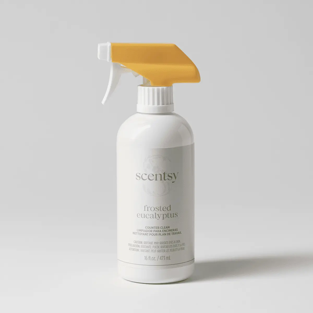 White spray bottle with a mustard-yellow trigger and soft grey label, the Frosted Eucalyptus Counter Clean, on a pale grey background