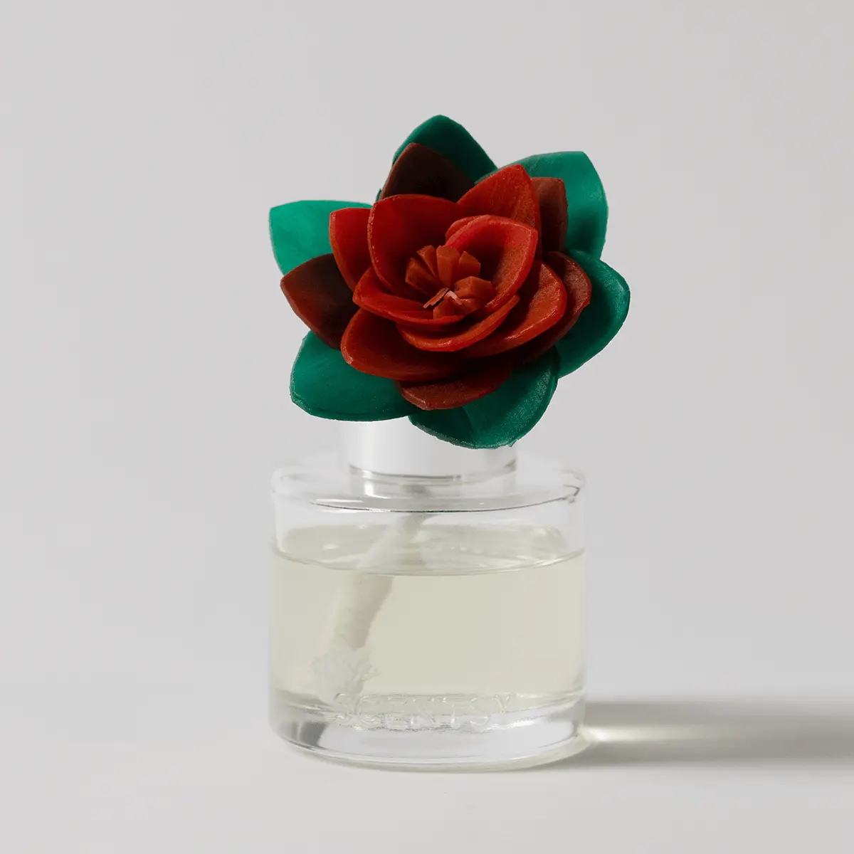 Red poinsettia-shaped Fragrance Flower with deep green leaves in a clear glass vial of liquid, the Hearthside Holiday - Radiant Red Poinsettia Fragrance Flower