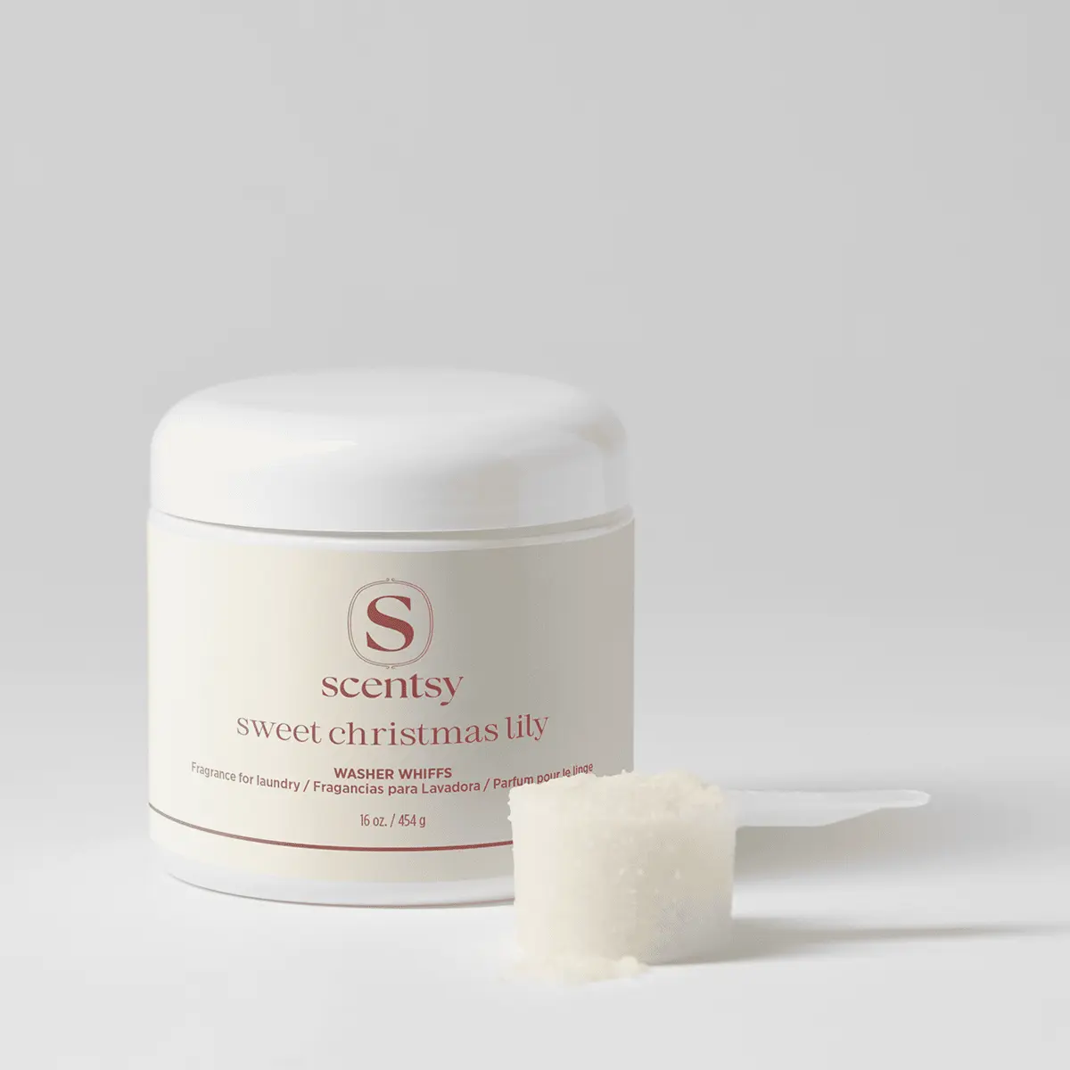 Cream-coloured cylindrical container with white lid and a single cream-coloured fabric scent disk, labelled Sweet Christmas Lily Washer Whiffs by Scentsy