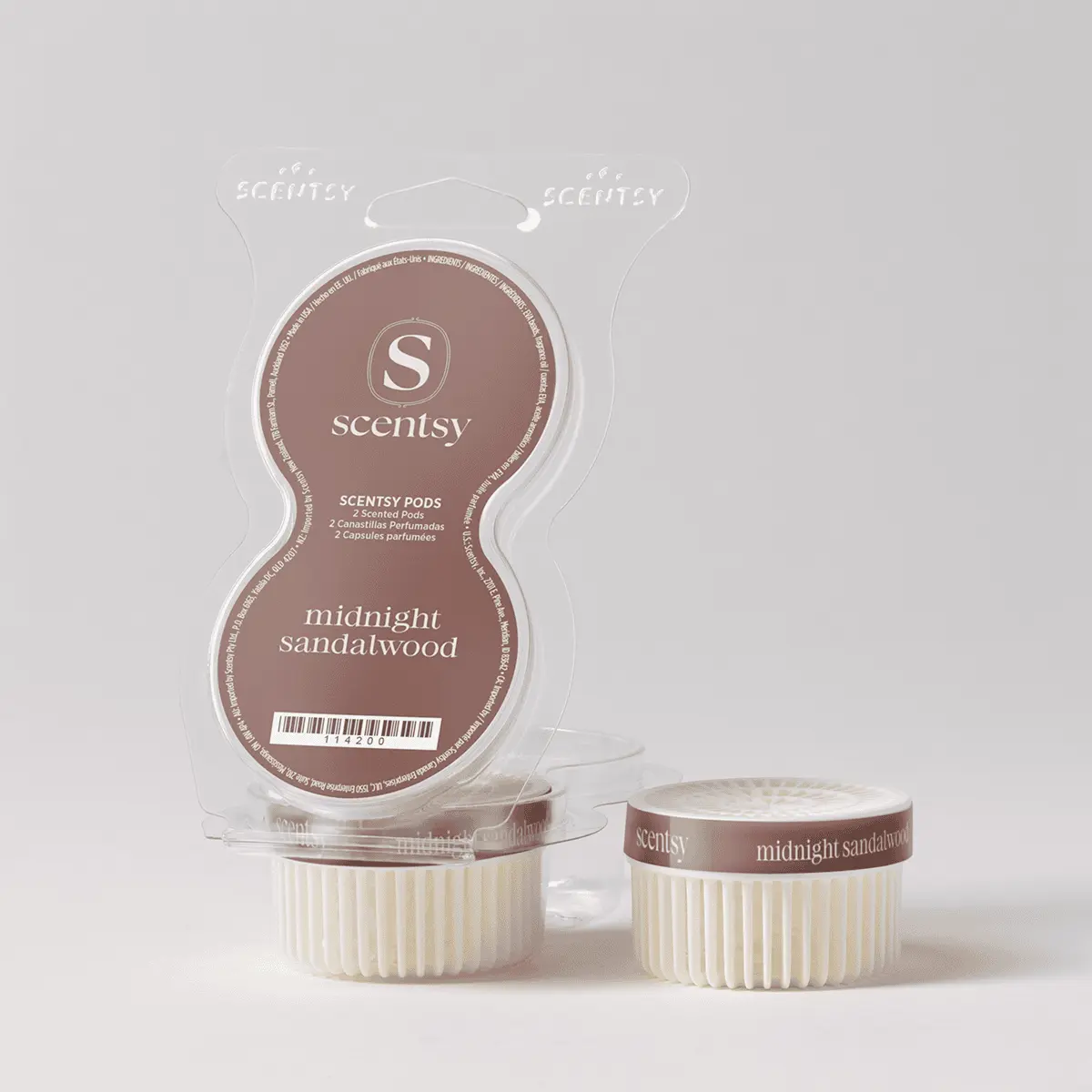 Clear plastic clamshell package containing two cream-coloured wax pods with brown bands labelled "midnight sandalwood" and the Scentsy logo, the Midnight Sandalwood Scentsy Pods