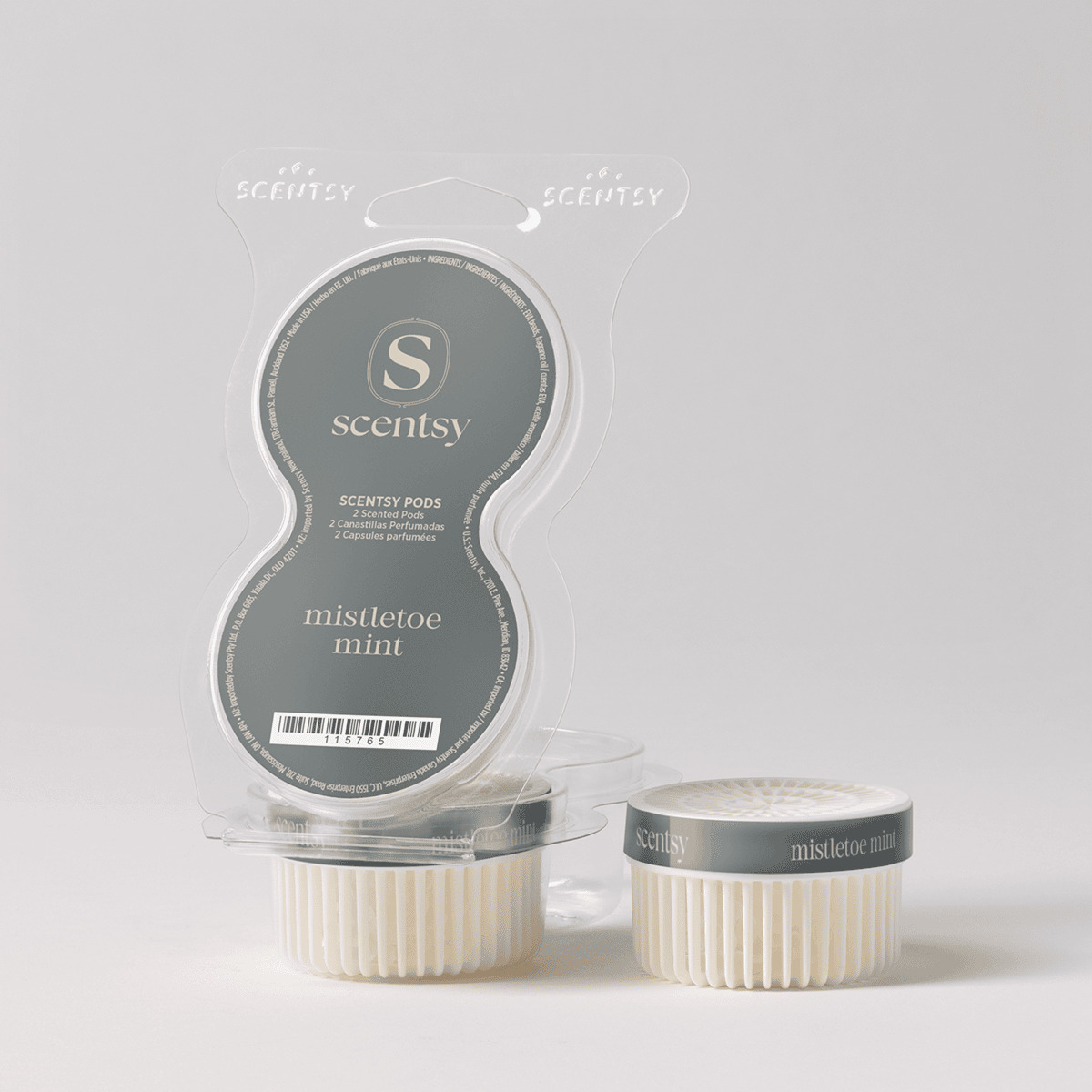 Two cream-coloured ridged Scentsy Pods with charcoal-grey bands labelled "mistletoe mint" beside their clear plastic clamshell packaging, the Mistletoe Mint Scentsy Pods