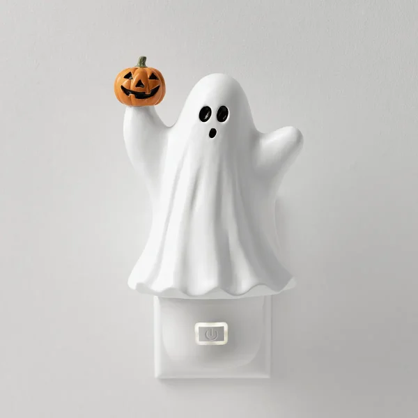 White ghost-shaped Scentsy Air Mini diffuser with black oval eyes and open mouth, holding an orange jack-o'-lantern pumpkin with carved face, power button visible at base, the Scentsy Air Mini - Pumpkin Spirit