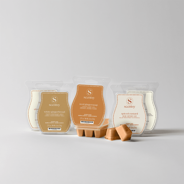 Three clear clamshell packs of Scentsy Bars and loose wax melts in cream, caramel, and orange tones, labeled White Gingerbread, Iced Gingernsnap, and Spiced Custard, composing the Gingerbread Scentsy Bar 5-pack