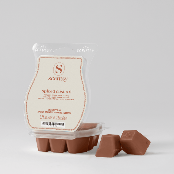 Brown wax bar segments with embossed S logo displayed with clear plastic clamshell packaging for Spiced Custard Scentsy Bar, showing ingredient details and net weight 2.6 oz