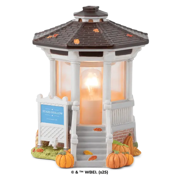 White gazebo-style Scentsy Warmer with a dark shingled roof, illuminated interior, decorative autumn leaves and pumpkins at the base, and a blue Stars Hollow sign, the Gilmore Girls: Welcome to Stars Hollow Scentsy Warmer
