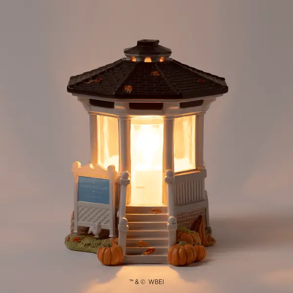 Illuminated miniature gazebo with a dark roof, cream-coloured panels, wooden stairs, and decorative pumpkins at the base, the Gilmore Girls: Welcome to Stars Hollow Scentsy Warmer