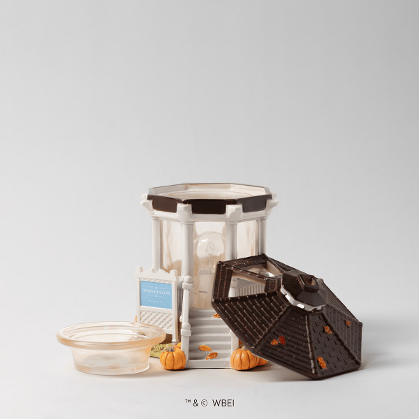 Cream ceramic warmer with a New England-style building facade, dark roof, and decorative autumn pumpkins, displayed with a wax tray and product card, the Gilmore Girls: Welcome to Stars Hollow Scentsy Warmer