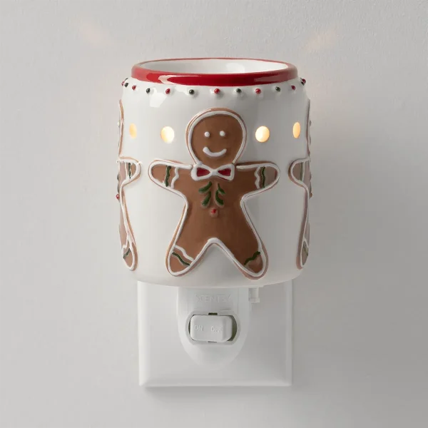 White ceramic plug-in warmer with a red rim and smiling gingerbread men in bow ties, lit from within, the Gingerbread Snap Mini Scentsy Warmer