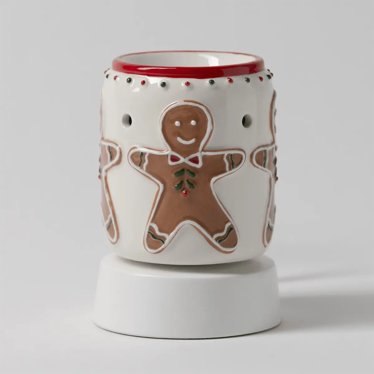 Cream ceramic mini warmer with gingerbread man design, red trim, decorative studs, and white tabletop base, the Gingerbread Snap Mini Scentsy Warmer