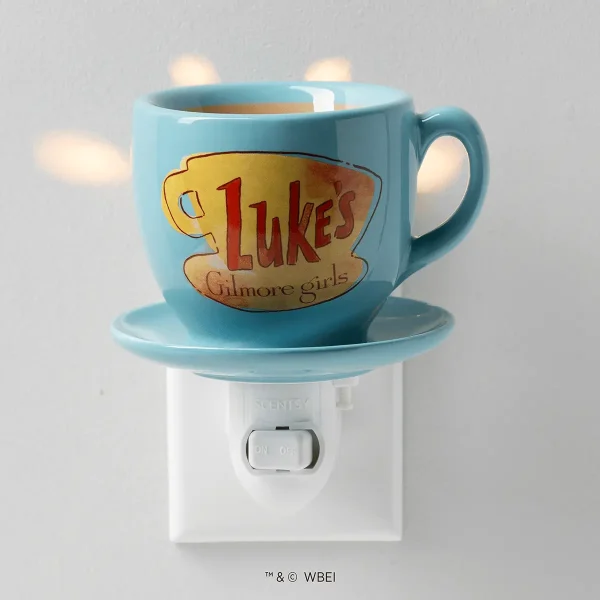 Light blue ceramic mug featuring a gold and red "Luke's" logo with "Gilmore girls" text, sitting on a matching saucer atop a white wall-plug warmer base with on/off switch, the Luke’s Coffee Mug Mini Scentsy Warmer