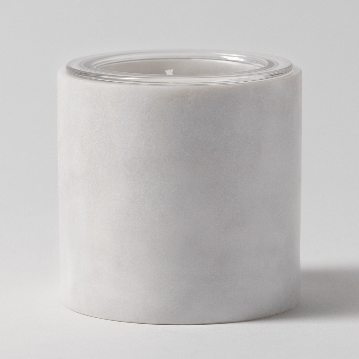 Cylindrical white marble candle holder with soft natural veining and a clear glass Scentsy Candle Insert filled with cream wax, the Marble Candle Holder