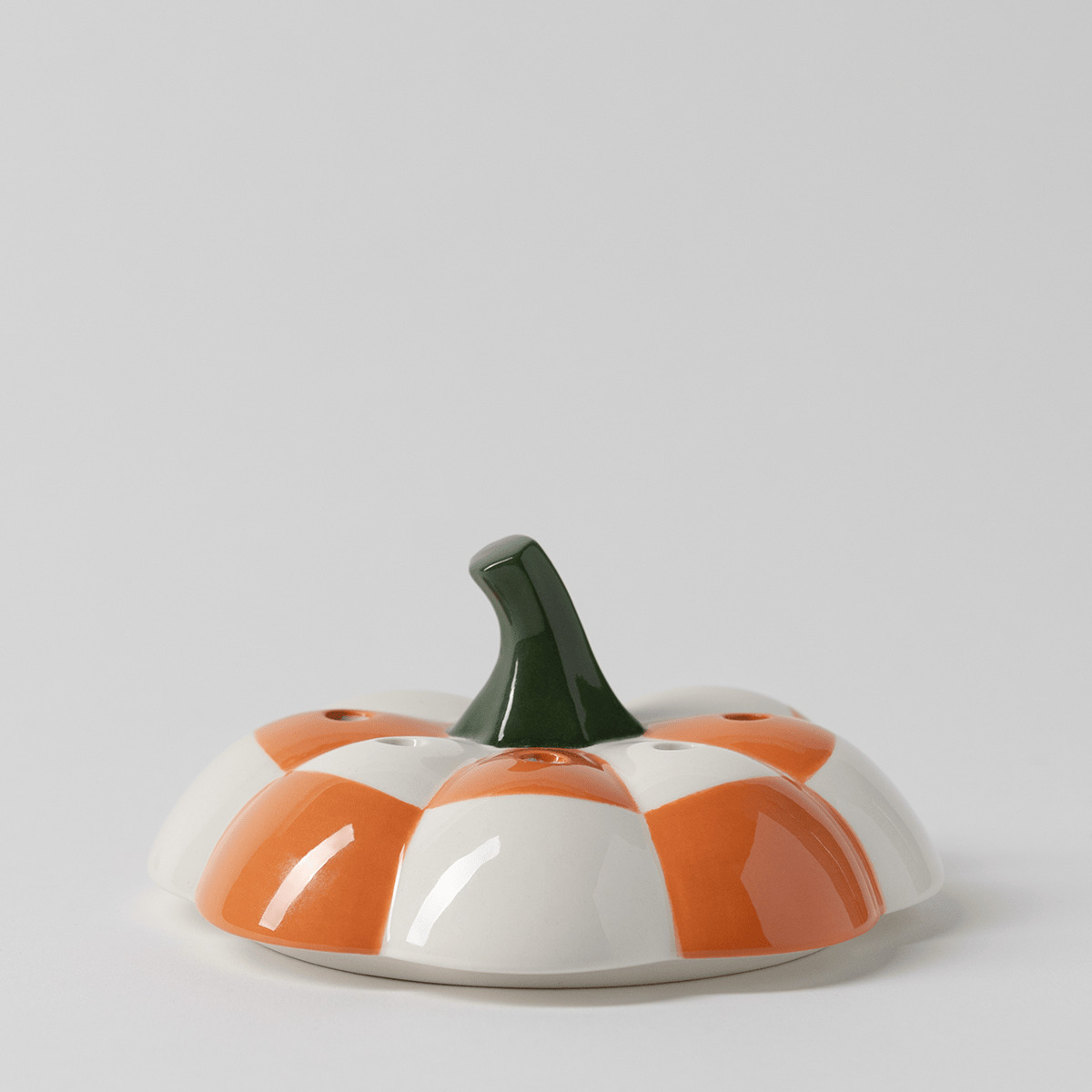 Glossy ceramic pumpkin-shaped lid with orange and white checked panels, small vent holes and a dark green stem, the Patchwork Pumpkin Replacement Lid