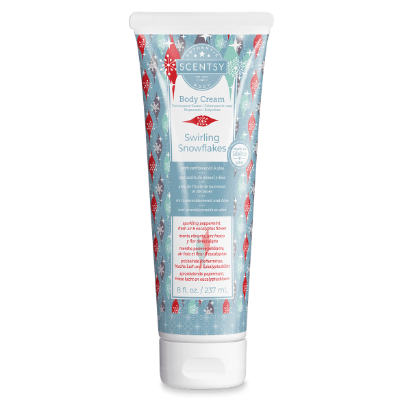 White squeeze tube with a white flip cap, wrapped in a blue label patterned with red, mint and purple ornaments and snowflakes, the Swirling Snowflakes Body Cream