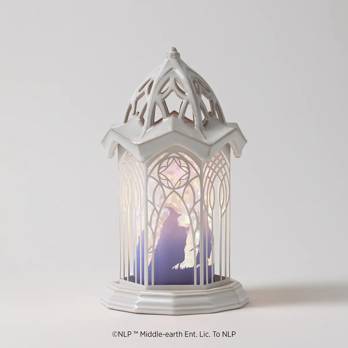White ceramic lantern warmer with an arched Gothic window design featuring a silhouette of a figure in purple and blue tones, The Lord Of The Rings: Rivendell Scentsy Warmer