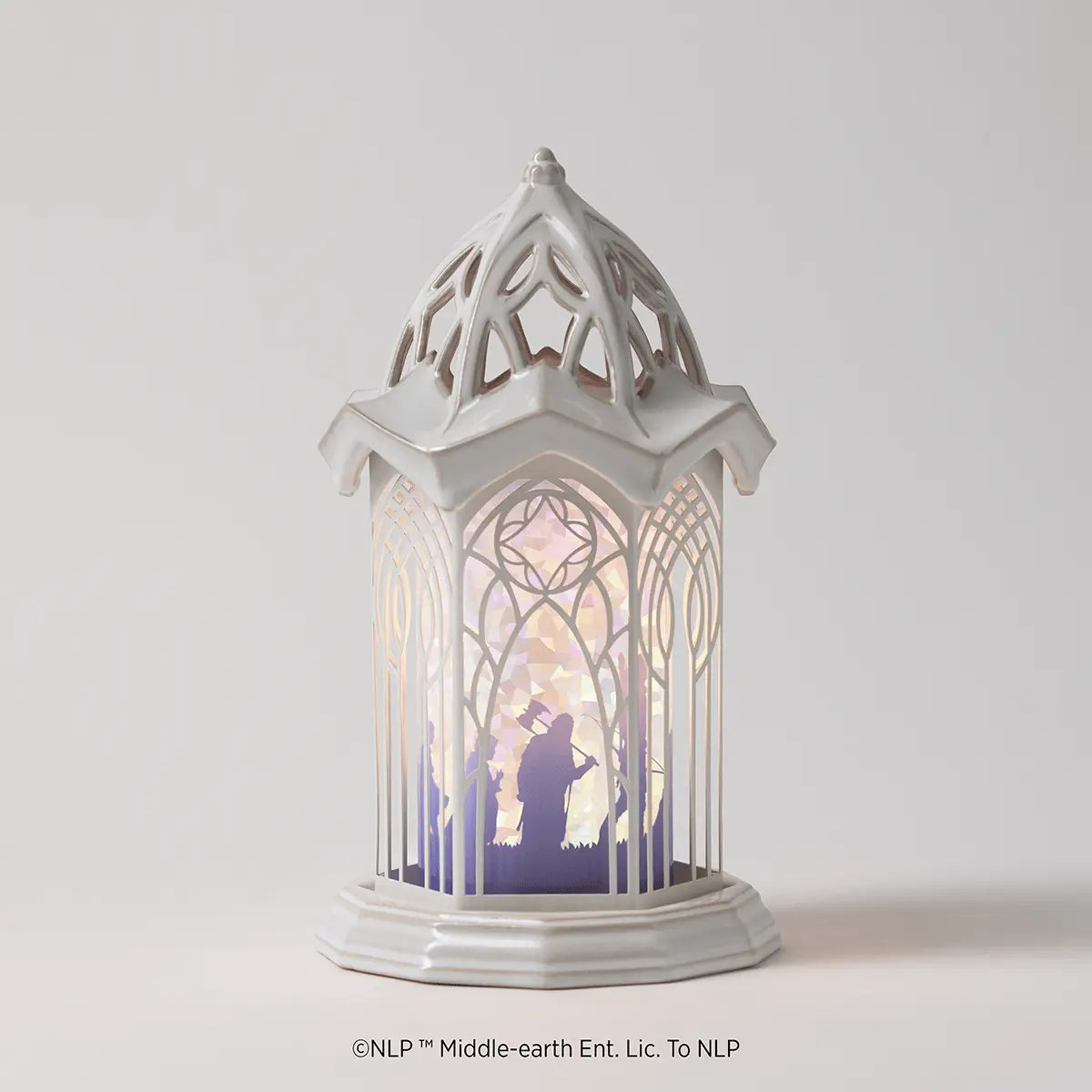 White ceramic lantern-style warmer with ornate Gothic architecture, featuring a silhouette scene of a figure in a magical landscape with purple and gold lighting, the Lord of the Rings: Rivendell Scentsy Warmer