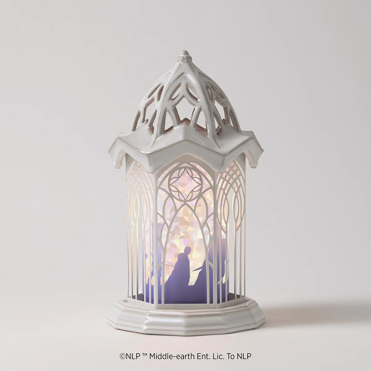 White ceramic warmer with an ornate Gothic-style tower structure, illuminated interior showing an elf figure beneath an arched window with geometric patterning, the Lord of the Rings: Rivendell Scentsy Warmer