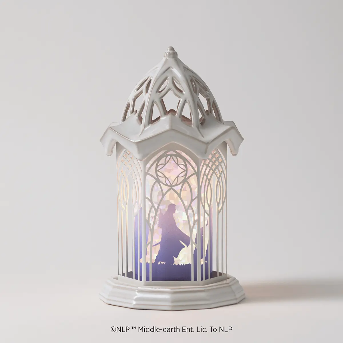 White ceramic warmer with a cathedral-style design featuring ornate geometric cutouts and an illuminated interior showing a silhouetted figure in a misty landscape, the Lord Of The Rings: Rivendell Scentsy Warmer