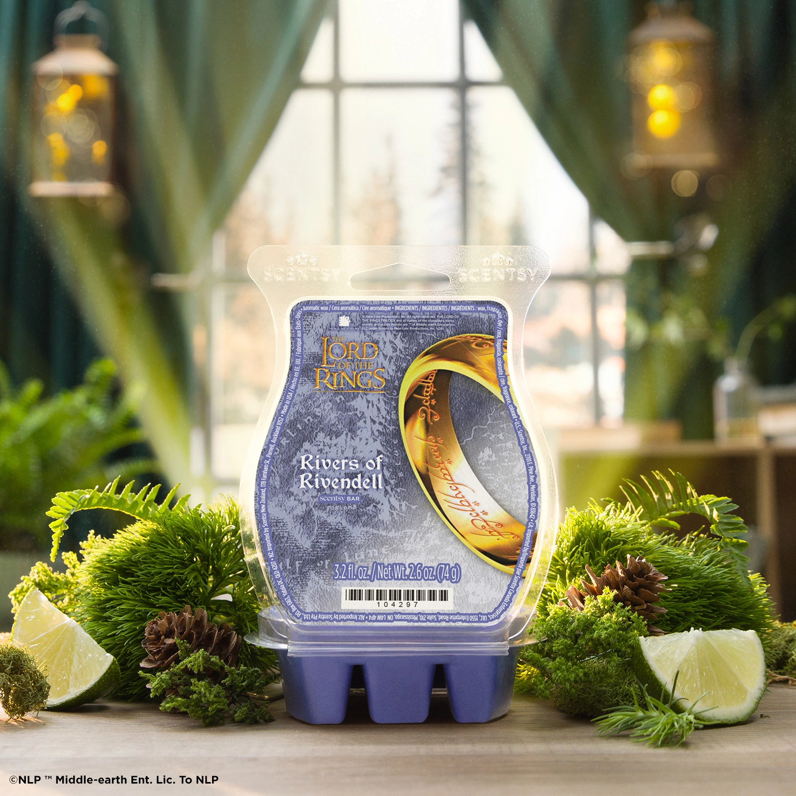 Clear plastic clamshell packaging with blue base and Lord of the Rings branding, featuring the One Ring design, surrounded by moss, pine cones and lime wedges in a window-lit setting