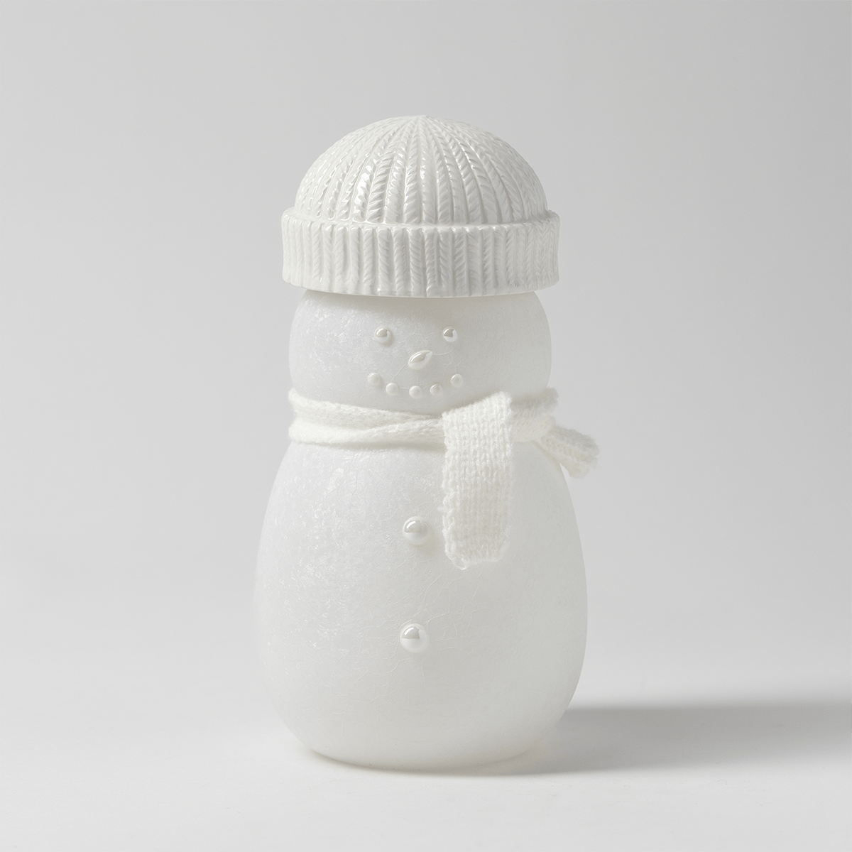White frosted snowman with a glossy cable-knit beanie, pearl button eyes and smile, and a knitted white scarf, the Frosty Charm Scentsy Warmer