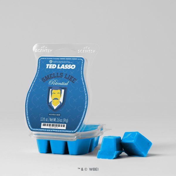 Bright blue wax cubes beside a clear clamshell with a blue Ted Lasso label featuring a moustached coach illustration, the Smells Like Potential Scentsy Bar